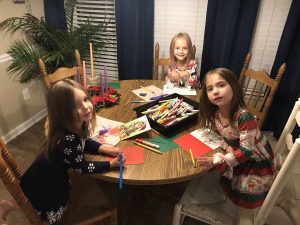 Kids writing letters to Santa at dinner table