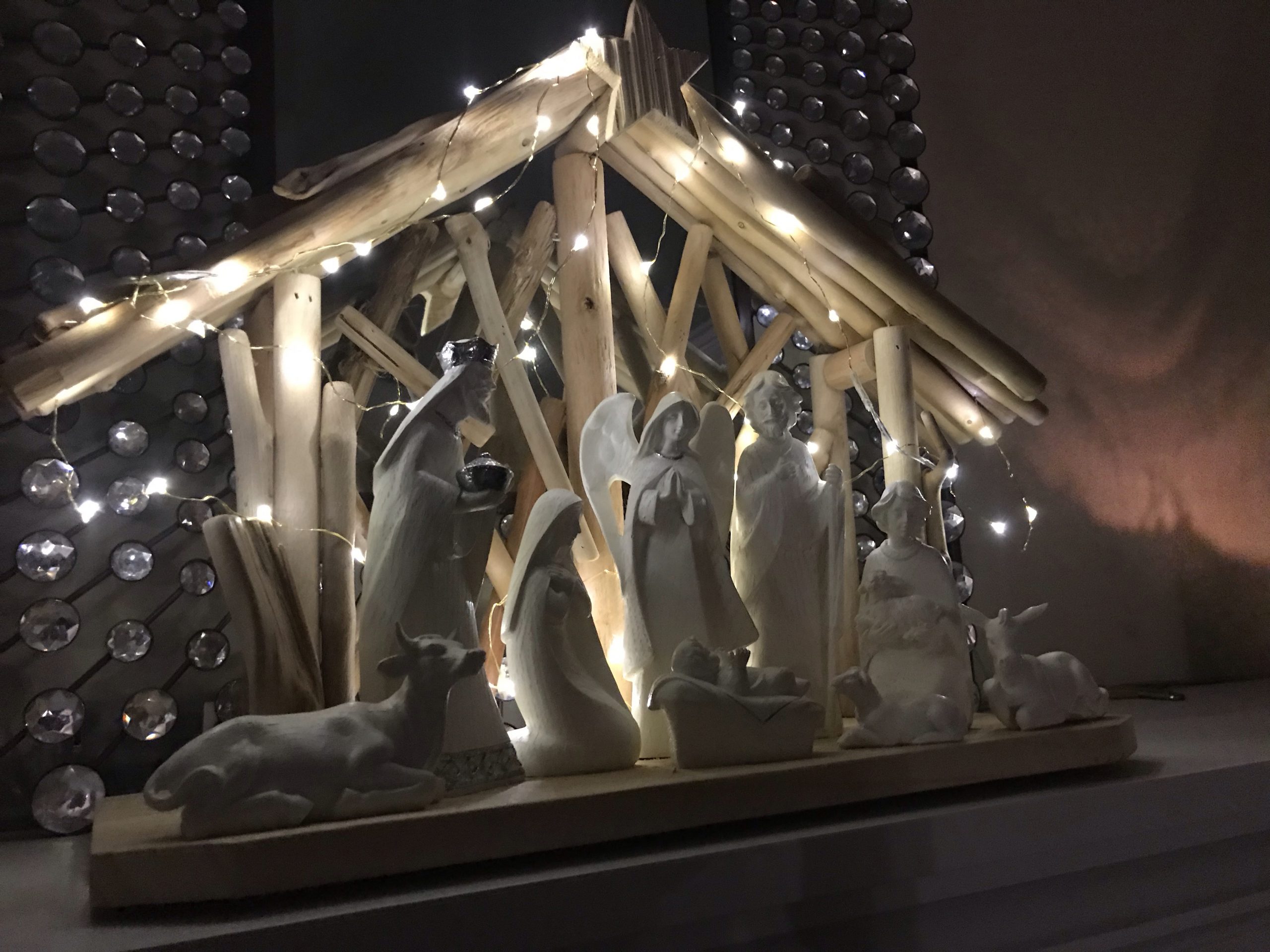 A nativity scene sitting on the mantle above a fireplace