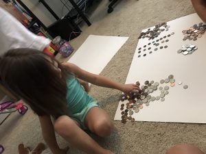 first grader doing math by counting coins