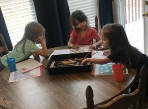 kids doing crafts around dining room table
