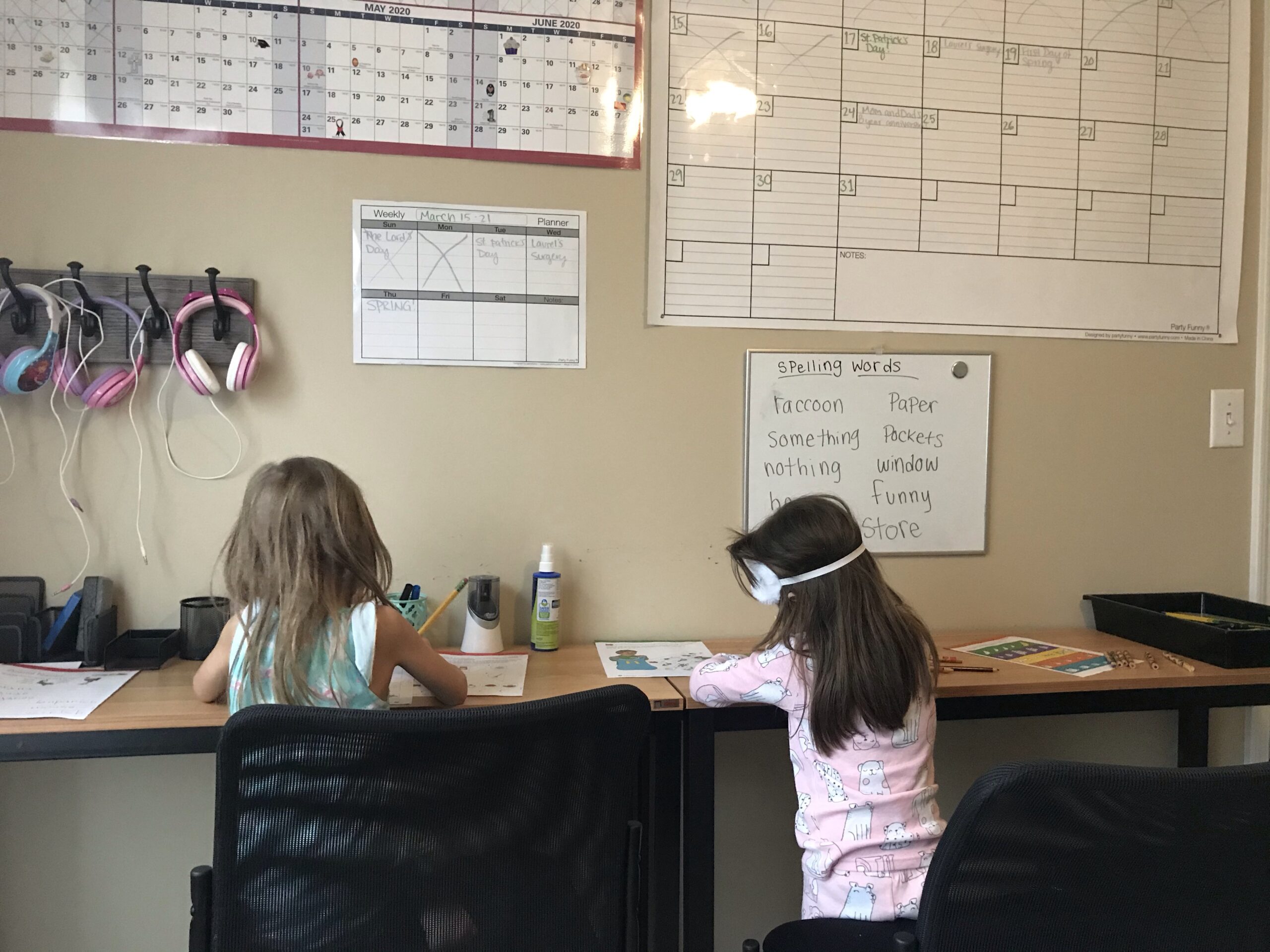 Two kids sitting at their homeschool desks, doing work.